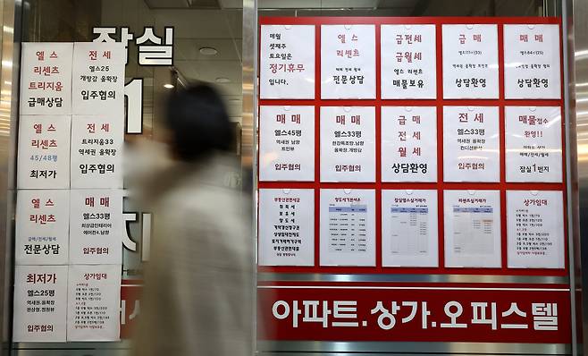 서울 잠실에 있는 공인중개사 사무실 유리 벽에 부동산 관련 세금과 아파트 매매 물건 등의 안내문이 게시되어 있다. /연합뉴스