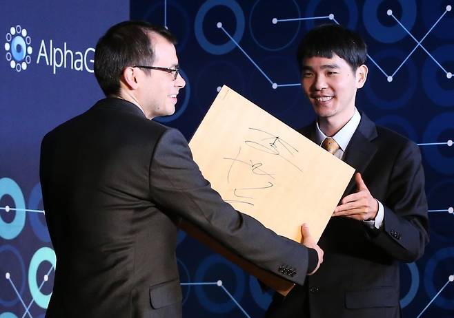 2016년 3월 15일 서울﻿에서 열린 ‘구글 딥마인드 챌린지 매치’에서 이세돌 9단(오른쪽)이 데미스 허사비스 구글 딥마인드 최고경영자(CEO)에게 대국에 사용한 바둑판에 서명한 뒤 선물하고 있다.  /한경DB