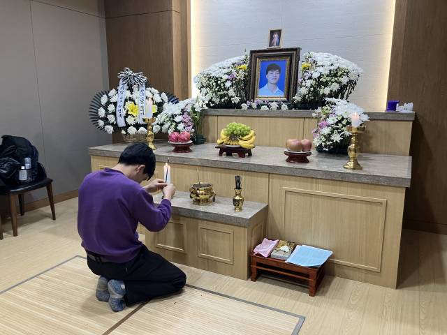 ▲3월 19일 오전 발인이 엄수되기 직전, 뚜안 씨의 오랜 친구가 고인의 영정사진 앞에서 향을 올리고 있다. ⓒ프레시안(손가영)