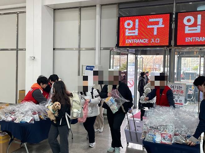 사료와 간식 등 선착순 선물을 받아 가는 사람들 [촬영 김세린]