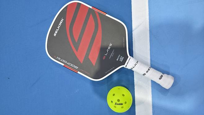 피클볼 코트 위에 놓인 패들과 공[사진/ 이동경 기자]