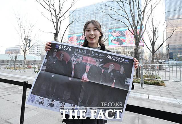 방탄소년단의 컴백쇼 'ARIRANG'을 앞두고 많은 사람들은 아침부터 광화문 광장을 찾아 현장 분위기를 만끽하고 있다. 사진은 한 외국인 팬이 신문사가 발행한 BTS 관련 특별판을 들고 기념촬영을 하는 모습이다./박헌우 기자