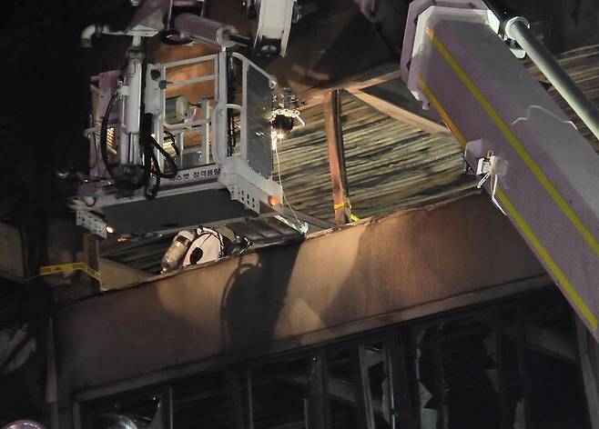 소방 구조대가 21일 자정께 불이 난 안전공안 공장 동관 건물 3층 창가에서 실종자 9명을 발견해 현장 보전 조처를 하고 있다. 최예린 기자