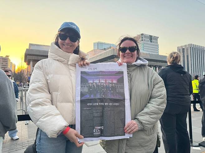 우루과이 출신 마리아(왼쪽, 42)와 스페인 출신 레오나르(40)가 방탄소년단(BTS) 컴백 공연 소식이 담긴 한겨레 특별판을 들어보이고 있다. 정봉비 기자
