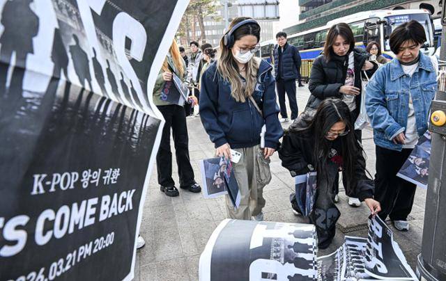 방탄소년단(BTS) 완전체 컴백 공연을 앞둔 21일 오전 서울 광화문 일대에서 일본인 관광객들이 한국일보가 발행한 BTS 특별판을 받고 있다. 류효진 선임기자