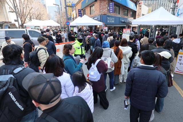 방탄소년단(BTS) 컴백 공연 당일인 21일 서울 종로구 광화문광장 일대 출입게이트에서 관광객들이 검문검색을 받기 위해 줄 서 있다. 뉴시스