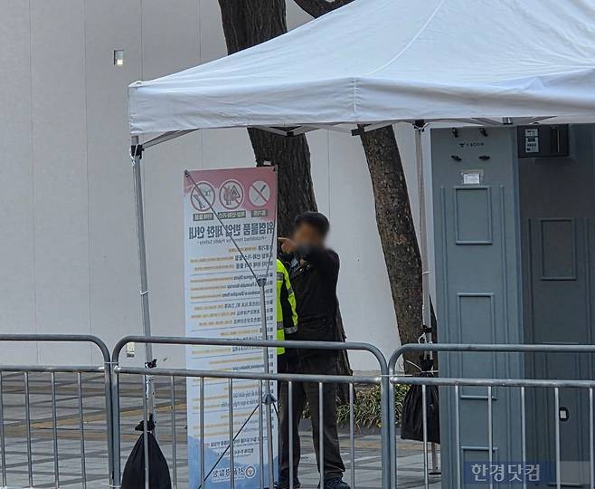 한 시민이 소지품 검사를 하려는 경찰과 실랑이를 벌이고 있다. /사진=이정우 기자