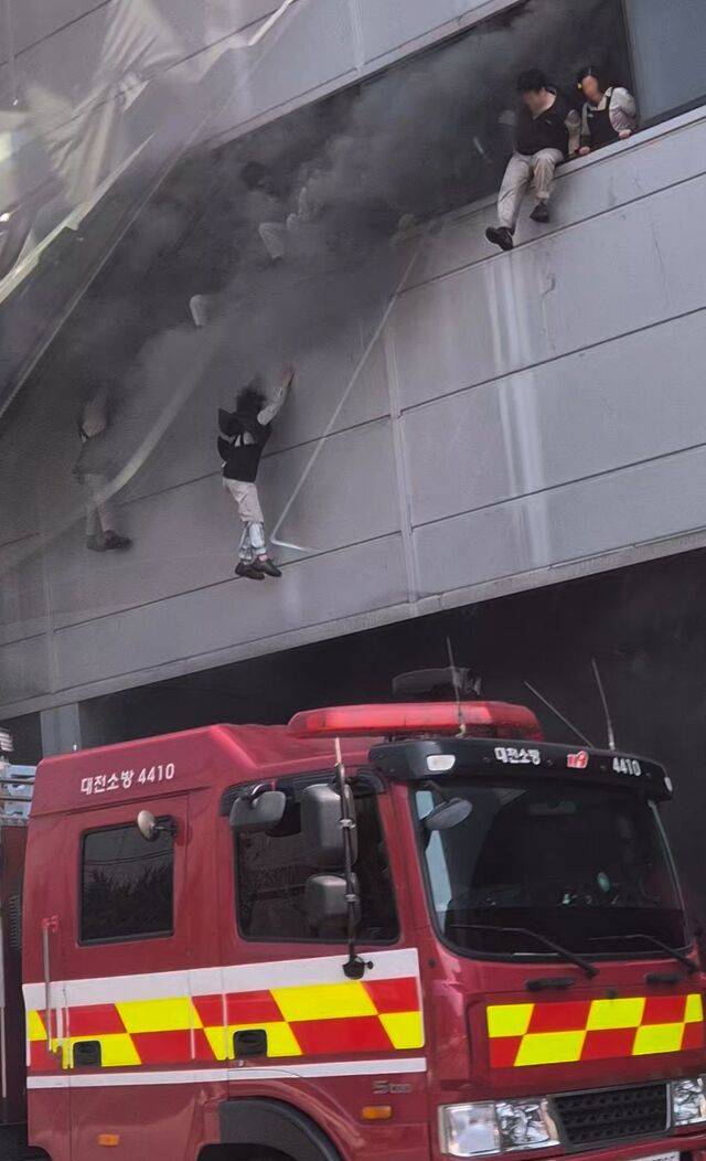 건물 내부에 있던 직원들이 필사적으로 뛰어내리고 있다. 연합뉴스