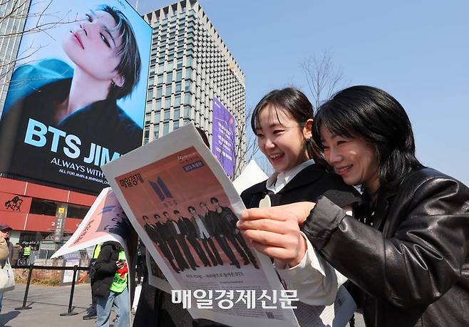 방탄소년단(BTS) 컴백 공연일인 21일 서울 광화문광장에서 외국인 관광객이 매일경제신문이 발행한 BTS 관련 특별판을 읽고 있다. [한주형기자]