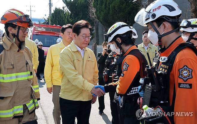 이재명 대통령이 21일 대전 대덕구 안전공업 건물의 대형 화재 현장을 찾아 구급대원들을 격려하고 있다. [공동취재]