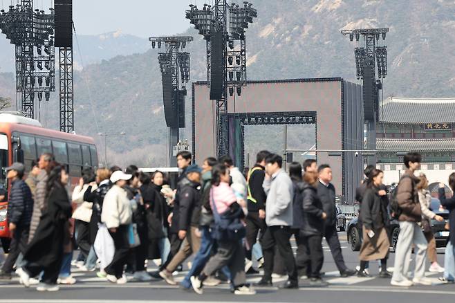 문화체육관광부가 21일 서울 광화문 일대서 열리는 방탄소년단(BTS) 복귀 공연과 관련해 서울 중구·종로구에 공연장 재난 위기경보 ‘주의’ 단계를 발령한다고 20일 밝혔다. 사진은 20일 공연장 부근에서 시민들이 이동하는 모습. [연합]