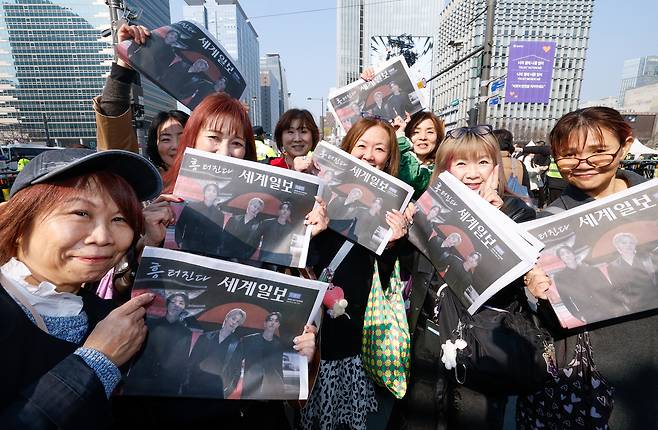 방탄소년단(BTS) 광화문 컴백 공연이 펼쳐지는 21일 서울 종로구 광화문 광장에서 일본인 아미(BTS 팬덤 명칭)들이 세계일보 특별판 지면을 들고 기념사진을 찍고 있다.
