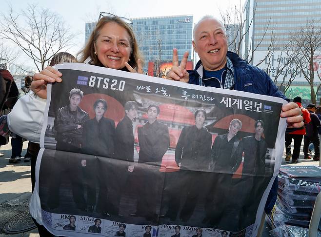 방탄소년단(BTS) 광화문 컴백 공연이 펼쳐지는 21일 서울 종로구 광화문 광장에서 외국인 아미(BTS 팬덤 명칭)들이 세계일보 특별판 지면을 들고 기념사진을 찍고 있다.