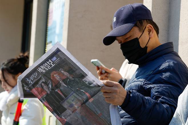 방탄소년단(BTS) 광화문 컴백 공연이 펼쳐지는 21일 서울 종로구 광화문 광장에서 한 시민이 세계일보 특별판 지면을 살펴보고 있다.