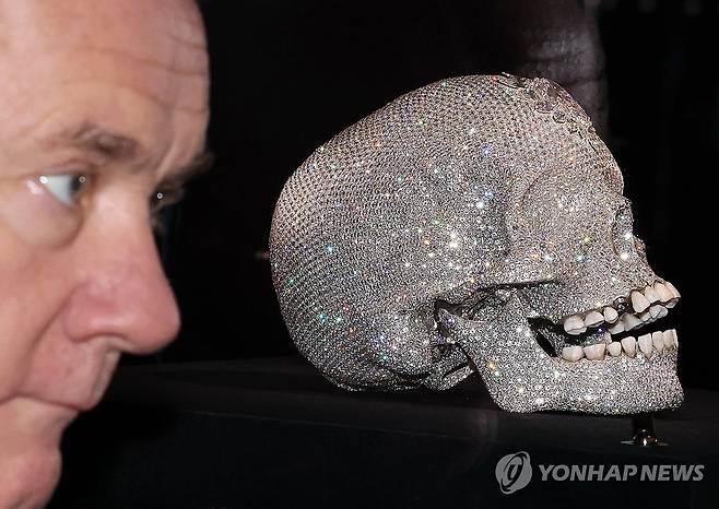 다이아몬드 해골과 포즈 취하는 데이미언 허스트 (서울=연합뉴스) 이재희 기자 = 영국 작가 데이미언 허스트가 18일 서울 종로구 국립현대미술관에서 열린 '진실은 없어 그러나 모든 것은 가능하지' 개인전에 전시된 '신의 사랑을 위하여' 작품 앞에서 포즈를 취하고 있다. 2026.3.18 scape@yna.co.kr