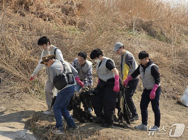 21일 서울 성동구 살곶이공원 인근 중랑천에서 열린 '세계 물의 날' 하천 정화 활동에서 자원봉사자들이 쓰레기로 덮인 닻을 건져서 운반하고 있다. ⓒ 뉴스1 황덕현 기자