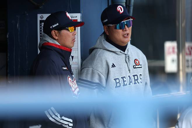 두산 김원형 감독(왼쪽)이 21일 서울 잠실구장에서 열린 2026 KBO리그 시범경기 KIA전을 보면서 이진영 타격코치와 대화하고 있다. 사진 | 두산 베어스