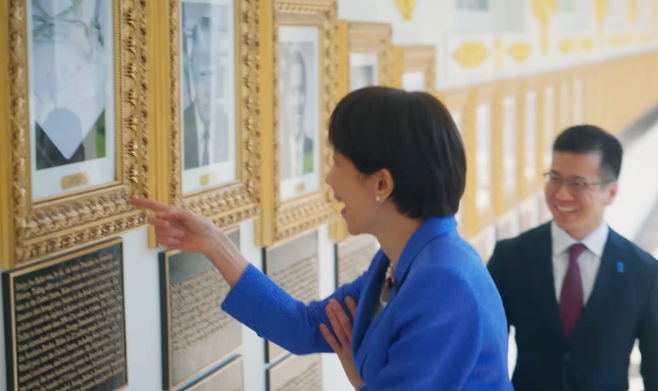 다카이치 사나에 일본 총리가 19일(현지 시간) 미국 워싱턴 백악관에서 조 바이든 전 미국 대통령의 초상화 대신 걸린 ‘자동 서명기(오토펜)’ 사진을 보고 웃음을 터뜨렸다. 유튜브 채널 ‘The White House’ 영상 갈무리