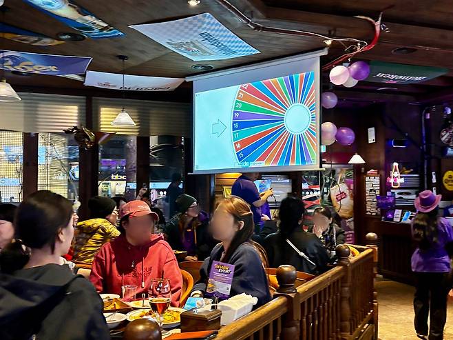 21일 밤 서울 중구 무교동 한 술집 안이 BTS를 상징하는 보라색 풍선 등으로 장식된 가운데 '아미(BTS 팬덤명)'를 상대로 한 뽑기 이벤트가 진행 중이다. 곽주영 기자