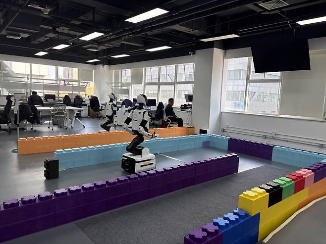 지난 20일 중국 베이징 남동쪽 이좡 경제기술개발구에 위치한 '베이징 휴머노이드 로봇 혁신 센터 시험·검증 플랫폼'에서 로봇들이 걷고 뛰면서 다양한 종류의 테스트를 받고 있다. 베이징=김은정 특파원