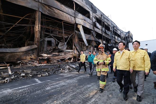 이재명 대통령이 21일 대전 대덕구 안전공업 건물의 대형 화재 현장을 찾아 피해 상황을 살펴보고 있다. 연합뉴스