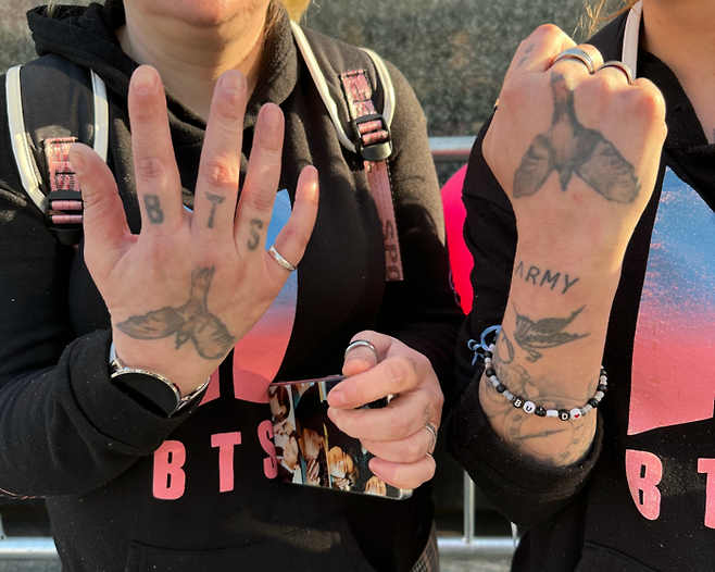 쌍둥이 자매가 손등과 팔목에 새긴 ‘BTS’·‘ARMY’ 타투를 공개하고 있다. 21일 오후 서울 광화문 동화면세점 인근. [구정근 기자]