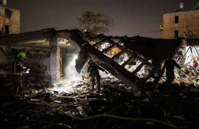 21일(현지시간) 이란의 미사일 공격을 받은 이스라엘 남부 디모나에서 구조대원들이 긴박하게 현장을 수습하고 있다. 로이터 연합뉴스