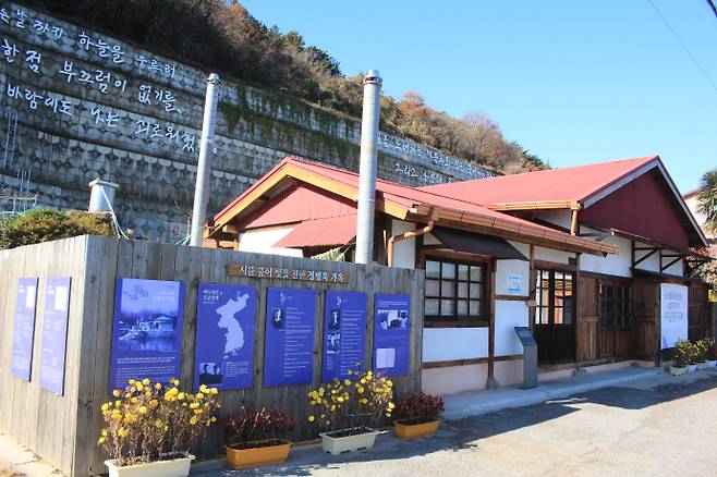전라남도 광양시 진월면 망덕 포구에 자리한 정병욱 가옥과 집 뒤 옹벽에 설치된 윤동주 시.
