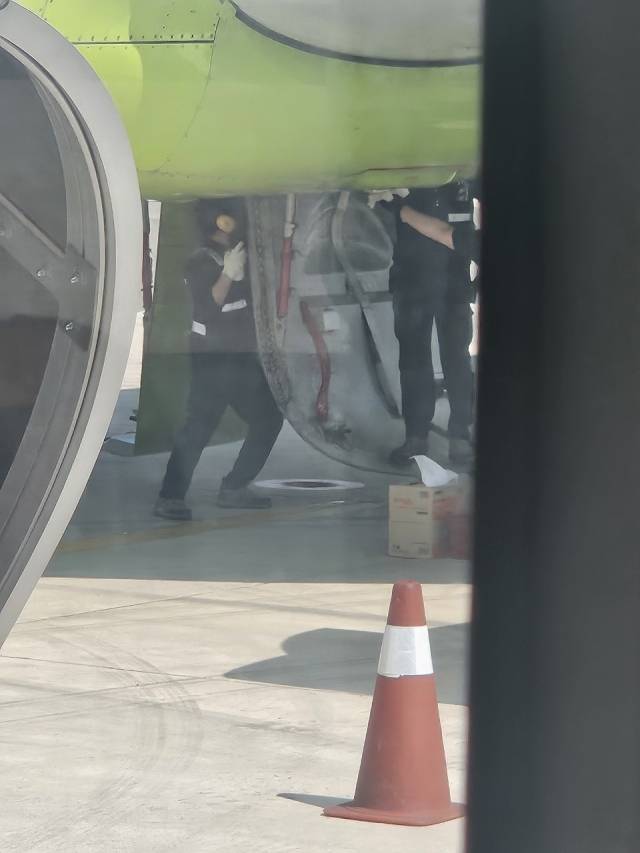 23일 낮 부산 김해공항에 착륙한 에어부산 BX8104편 여객기에 정비 인력이 투입돼 현장 정비를 진행하는 모습. 독자 제공