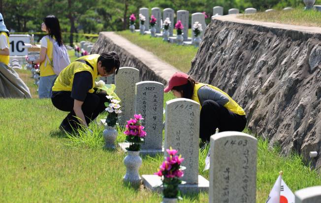 2025년 6월, 오뚜기 봉사단이 국립서울현충원 장병묘역에서 비석 닦기 봉사활동에 참여하고 있다.(사진제공=오뚜기)