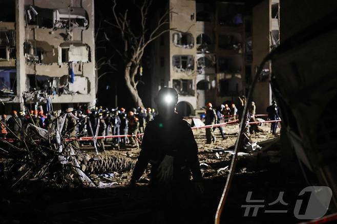 22일(현지시간) 새벽 이스라엘 구조대가 전날 이란 미사일 공격을 받은 아라드의 건물들을 점검하고 있다.2026.03.22. ⓒ AFP=뉴스1