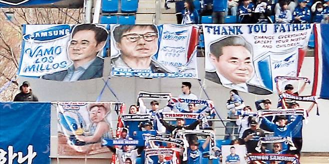 과감한 투자 바라는 팬들 “가자, 백만장자여”  수원 삼성 팬이 내건 이재용(왼쪽부터) 삼성전자 회장과 이정효 감독, 고(故) 이건희 선대회장 배너. 이건희 회장 걸개엔 ‘고맙습니다, 아버지’란 문구 아래 ‘마누라와 자식 빼고 다 바꿔라’는 ‘신경영 선언’이 영어로 적혀 있다. 이재용 회장 배너에는 아르헨티나 리버 플레이트 응원 구호인 ‘Vamo Los Millos(가자, 백만장자들)’를 썼는데, 구단에 과감한 투자를 바라는 팬들의 염원이 담겼다. /프로축구연맹