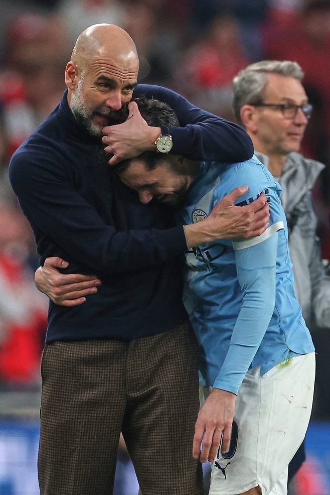 맨체스터 시티의 감독 펩 과르디올라가 23일 열린 카라바오컵 결승전에서 맹활약한 후 후반전 교체로 나온 랴얀 셰르키를 끌어안으며 격려하고 있다./AP 연합뉴스