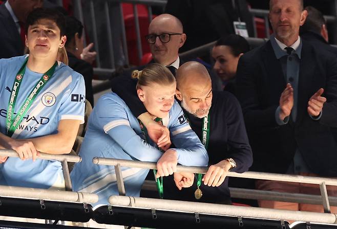 23일 잉글랜드 리그컵 우승을 차지한 뒤 우승 메달을 건 펩 과르디올라가 공격수 에링 홀란과 기뻐하고 있다./로이터 연합뉴스