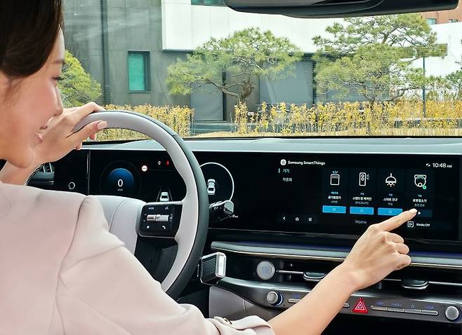 삼성전자 모델이 차량에서 집 안 가전기기를 제어하는 '카투홈(Car-to-Home)' 서비스를 체험하고 있다. 삼성전자 제공