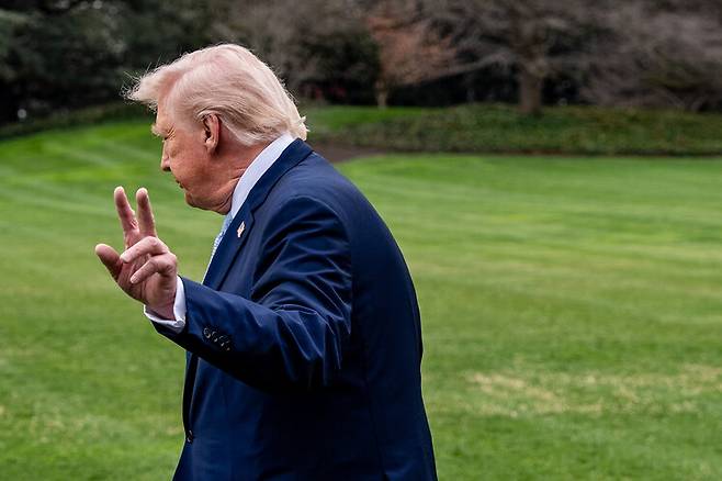 도널드 트럼프 미국 대통령이 20일(현지시각) 백악관 잔디밭에서 전용 헬기인 ‘머린 원’에 오르기 전 취재진 카메라를 향해 손을 흔들고 있다. 워싱턴/AP 연합뉴스
