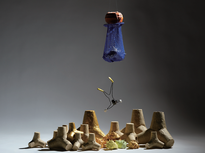 나강 作 'Under the Sea'. 매달린 오브제와 낙하 직전의 긴장. 지지와 이탈이 동시에 작동하는 구조 속에 균형은 끝내 고정되지 않는다.