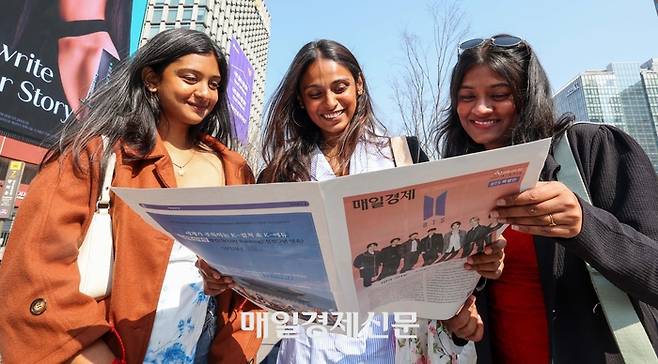 BTS 컴백 공연일인 21일 서울 광화문광장에서 외국인 관광객이 매일경제신문이 발행한 BTS 관련 특별판을 읽고 있다. [한주형기자]