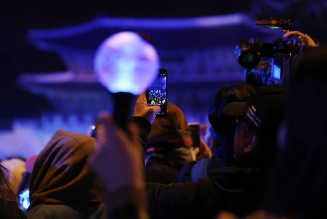 21일 서울 광화문 광장에서 그룹 방탄소년단(BTS)의 정규 5집 ‘아리랑’(ARIRANG) 발매를 기념해 열린 무료 공연 ‘BTS 컴백 라이브: 아리랑’(BTS THE COMEBACK LIVE｜ARIRANG)을 찾은 팬들이 응원봉을 든 채 휴대전화 카메라로 BTS의 공연 모습을 촬영하고 있다. [연합뉴스]