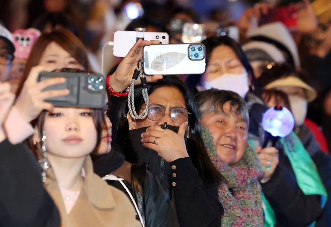 아미(BTS 팬덤)와 시민들이 21일 서울 광화문광장 일대에서 방탄소년단(BTS) 컴백 기념 공연인 ‘BTS 컴백 라이브: 아리랑’ 공연을 관람하고 있다. [뉴스1]