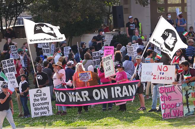 [댈러스=AP/뉴시스] 22일(현지 시간) CBS 뉴스와 여론조사기관 유고브(YouGov)가 발표한 최신 여론조사 결과에 따르면, 미국의 대이란 군사 행동에 반대한다는 응답은 60%를 기록했다. 사진은 1일 미 텍사스주 댈러스 도심 딜리 플라자에서 미국과 이스라엘의 이란 공습 반대 시위대가 현수막과 손팻말을 들고 있다. 미국 전역에서 이란 공습을 지지하거나 반대하는 시위가 열렸다. 2026.03.23.