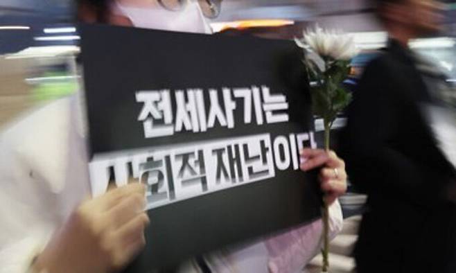 ‘전세사기 피해자 추모행진’에서 한 참가자가 피켓을 들고 있다. 연합뉴스