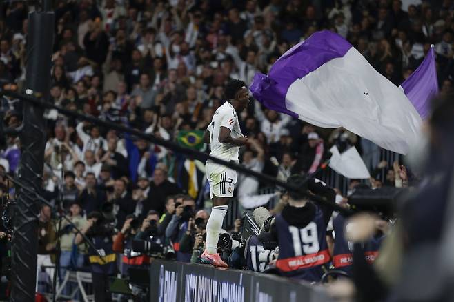 레알 마드리드 비니시우스가 23일 아틀레티코 마드리드전에서 결승골을 넣은 뒤 광고판에 올라가 팬 앞에서 세리머니하고 있다. EPA연합뉴스