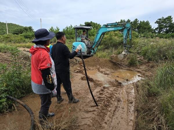 인천 옹진군 승봉도 주민들이 진흙탕이 된 둘레길을 중장비를 이용해 정비하고 있다. /승봉도 관광발전협의회 제공