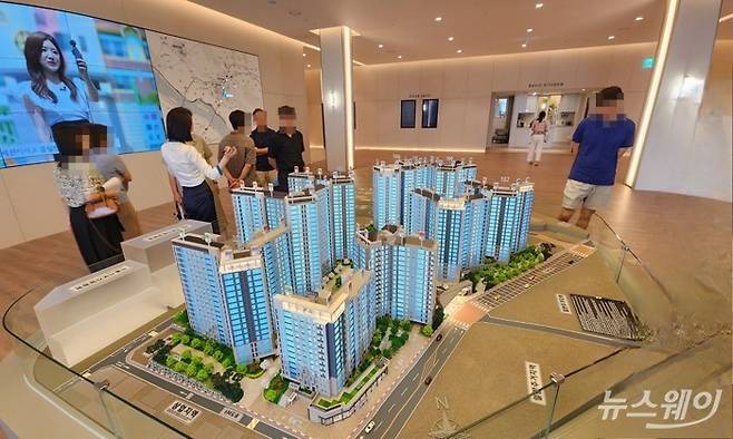 수도권 한 아파트 모델하우스에 마련된 단지 모형도를 관람객들이 둘러보고 있다. 사진=권한일 기자