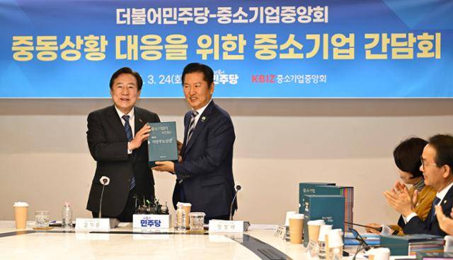 김기문(왼쪽) 중소기업중앙회장이 24일 서울 여의도 중기중앙회관에서 열린 중동 상황 대응을 위한 간담회 중 정청래 더불어민주당 대표에게 지방중소기업 성장전략 제안서를 전달하고 있다. 강예진 기자