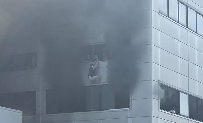 지난 20일 대전시 대덕구 문평동 자동차 부품 공장에서 화재가 발생하자 건물 2층에 있던 직원들이 창문에 매달려 구조를 기다리고 있다. [사진 한서현씨]