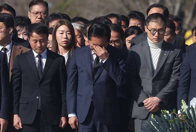 정청래 더불어민주당 대표가 23일 오전 경남 김해시 진영읍 봉하마을 노무현 전 대통령 묘역을 참배하며 눈물을 흘리고 있다. 왼쪽은 한병도 민주당 원내대표, 오른쪽은 김상욱 울산시장 후보. 연합뉴스