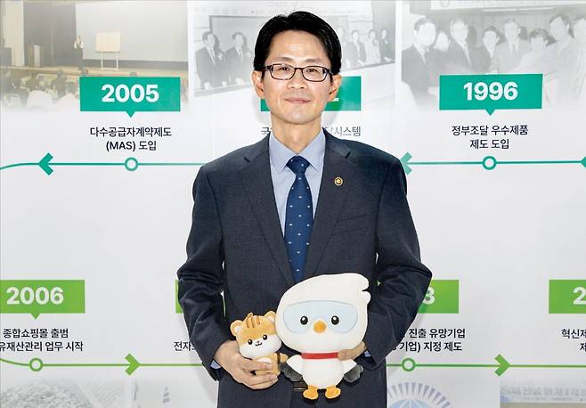 백승보 조달청장이 정부대전청사 조달전시관에서 조달청 마스코트인 나르미를 안고 코리아 나라장터 엑스포 2026을 홍보하고 있다. /조달청 제공