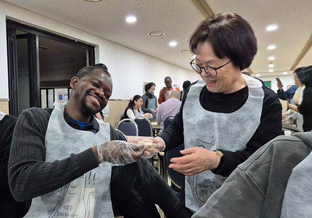 케냐에서 온 의사 조지 오레라(왼쪽)씨가 지난 21일 서울 마포구 서현교회에서 진행된 문화교실에서 자신이 빚은 만두를 한 봉사자에게 보여주며 환하게 웃고 있다.